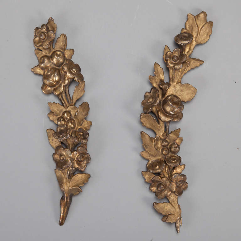 This pair of circa 1900 carved wood architectural pieces have a gilt finish and depict curved stems of flowers and leaves.