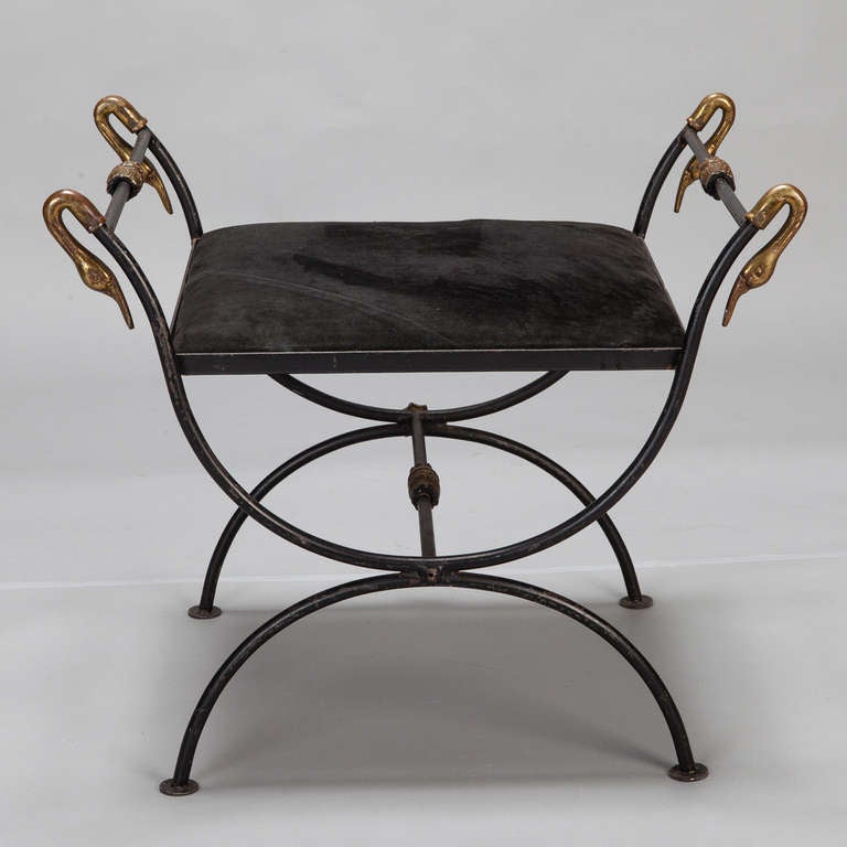 Circa 1960s stool or bench with black wrought iron savonarola style base, upholstered seat and ornamental brass swans. Seat is 16.5” high and 17” deep.