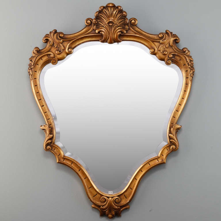 Circa 1920s French bevel edge mirror with beautifully detailed gilded wood frame and elaborate shell form crest.
