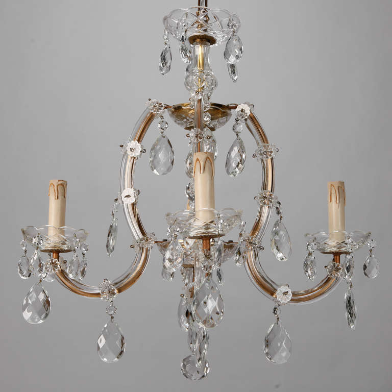 Circa 1930s classic Maria Theresa form crystal chandelier with four candle arms and large, faceted crystal drops. New wiring for US electrical standards.