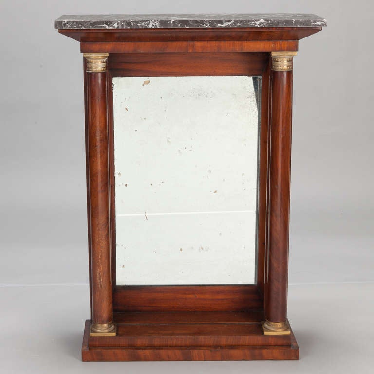 Circa 1900 French console table with a wood two tier platform base, etched brass fittings and column style supports. Mirrored back and a black and white marble table top. 
