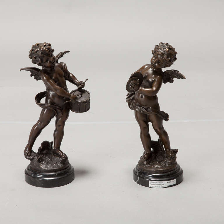 Circa 1900 angels are beautifully rendered in bronze. Both figures have wings; one is playing a drum while the other has cymbals. Sold and priced as a pair. 