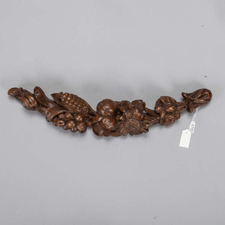 Circa 1900 French carved wood piece is slightly curved with beautifully rendered flowers and fruit.  This piece can be displayed on a wall, shelf/table or mounted on a stand.