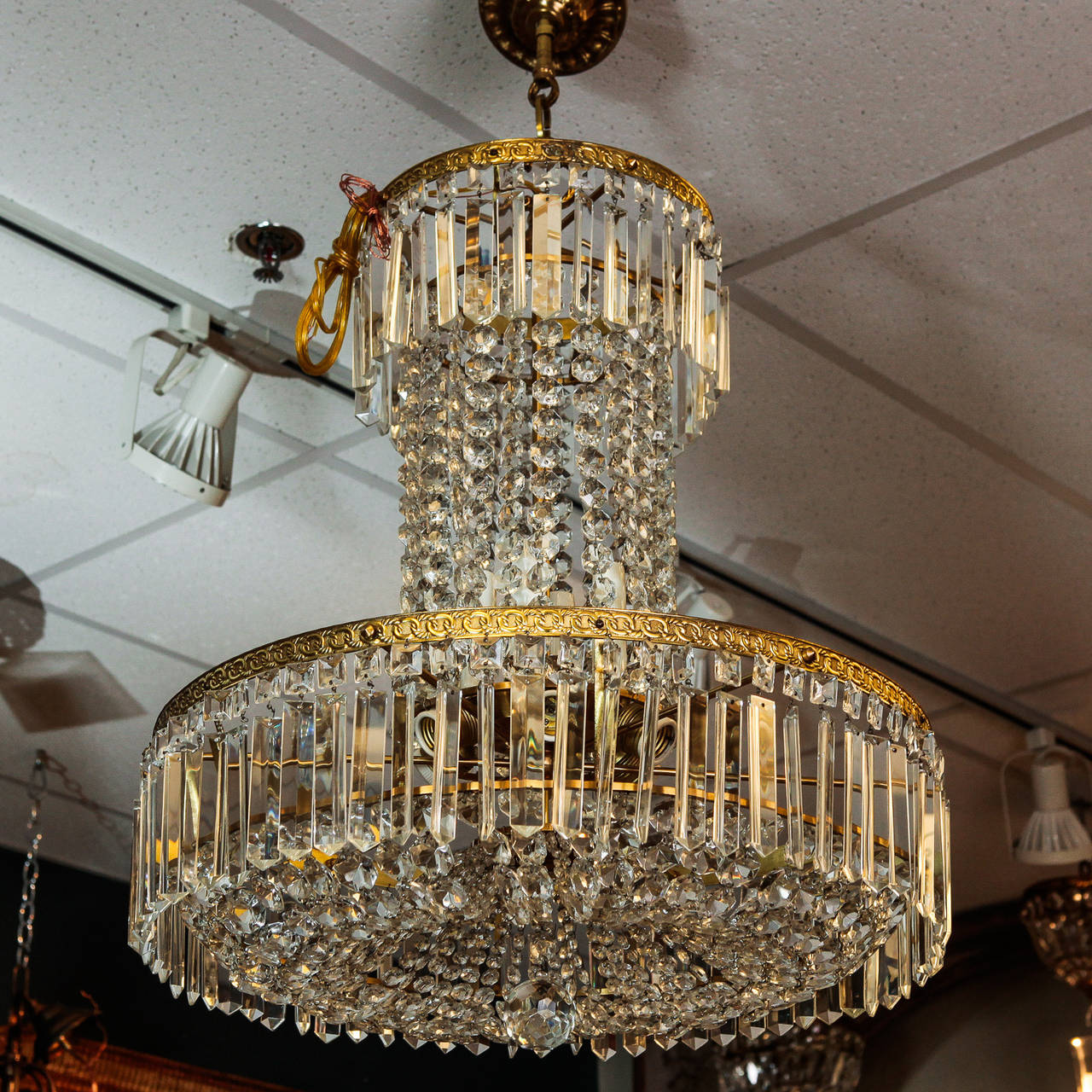Tall all crystal Swedish chandelier with decorative brass frame and rectangular crystal pendants with a center drop and tall center of draped crystal beading topped with another decorative brass frame and more crystal pendants, circa 1890s. New