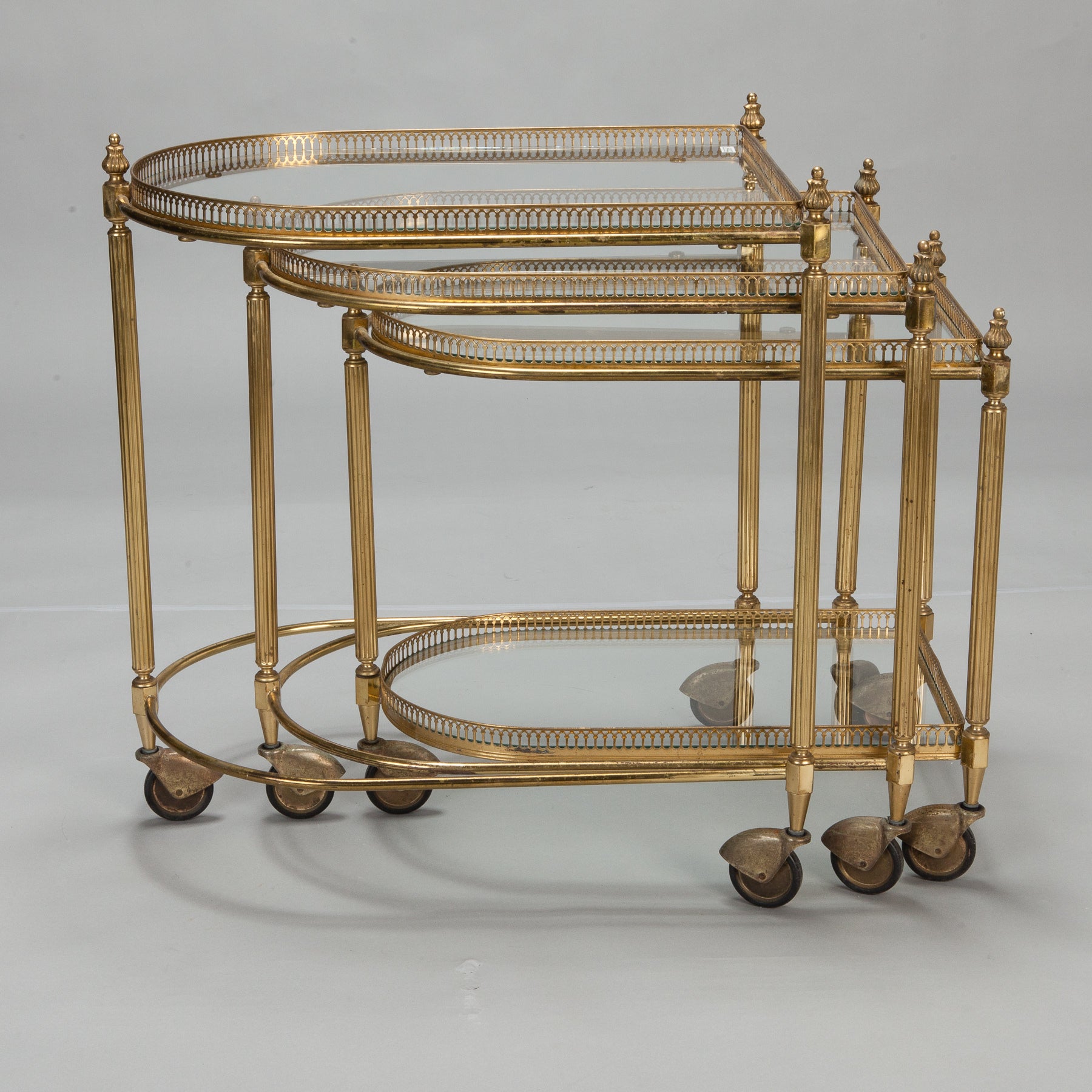 Three Piece Neoclassical Brass and Glass Nesting Tables on Casters