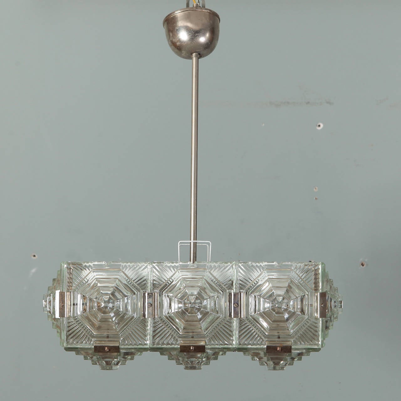 Circa 1970s European hanging light fixture with heavy, clear glass panels. Textured, dimensional glass with octagonal medallions and silver tone metal shaft and ceiling canopy. New wiring for US electrical standards.