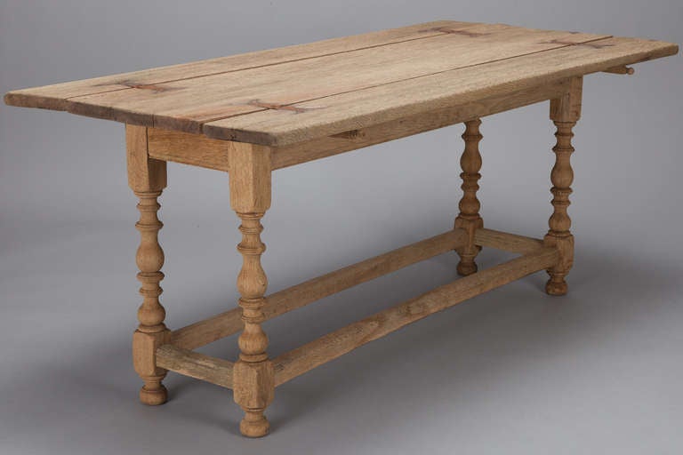 Circa 1890s bleached oak table with two leaves that fold down. Depth shown is with both leaves extended. Depth with leaves down is 15.75”. Rectangular base and nicely turned legs. 