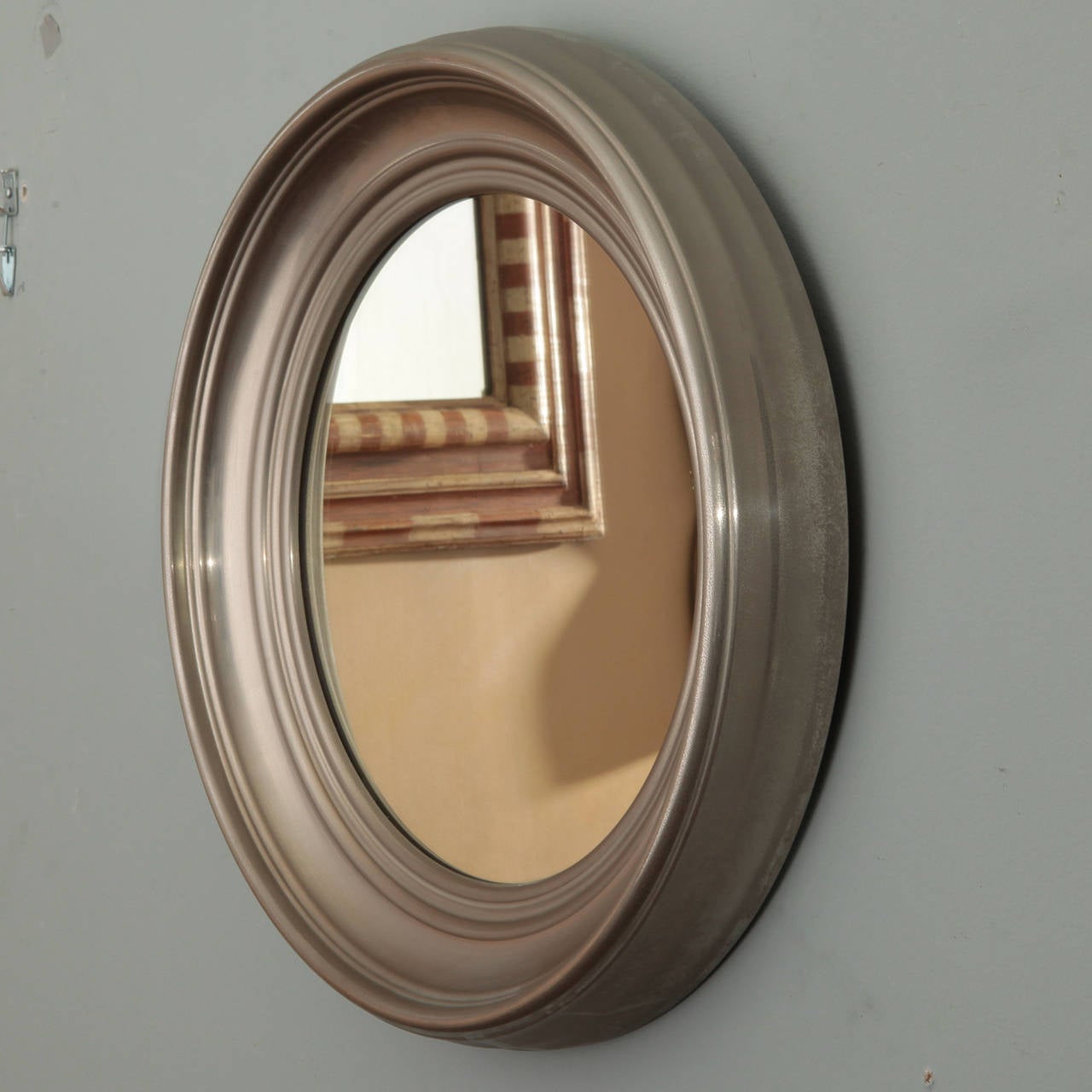 Found in France, this circa 1930s round mirror has a deep, silver tone metal frame.