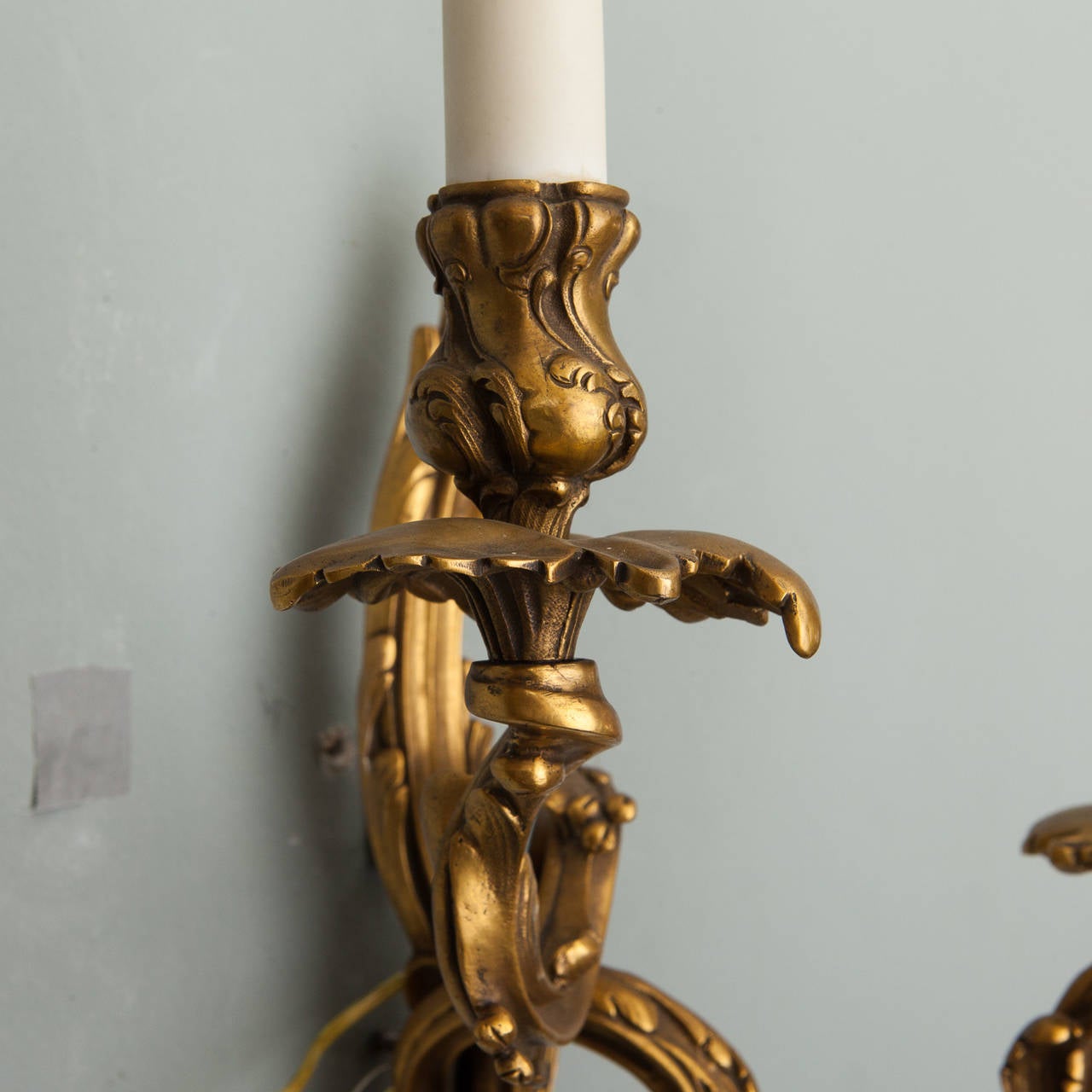 Circa 1900 French Louis XVI style bronze sconces with two candle arms. Sockets are for candelabra bulbs. New electrical wiring for US standards.