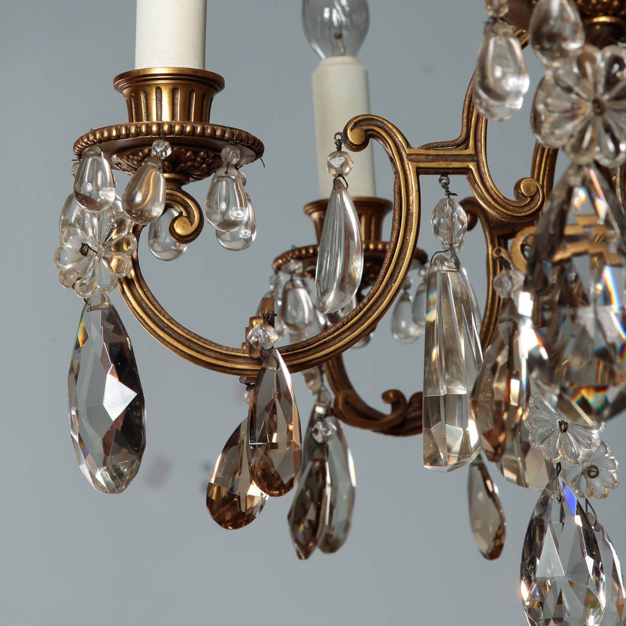 Circa 1900 French chandelier with gilded bronze frame with six candle style lights and clear crystal pendants. New wiring for US electrical standards.