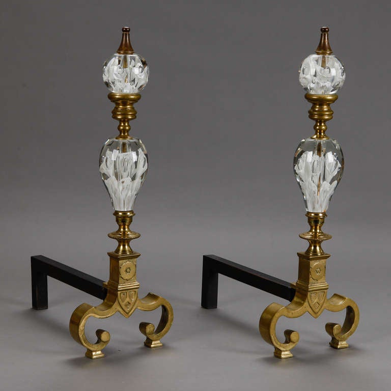 Fabulous pair of French chenets with large clear and white glass ornamental pieces and brass base. Sold and priced as a pair. Depth of base is 15” and depth of tall front pieces are 3.5”