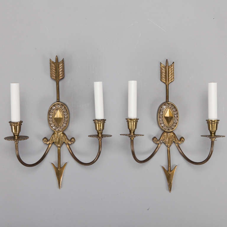 Circa 1920s pair of brass sconces with two arms, candle style lights and a back plate with an arrow and clear beads. New wiring for US electrical standards.