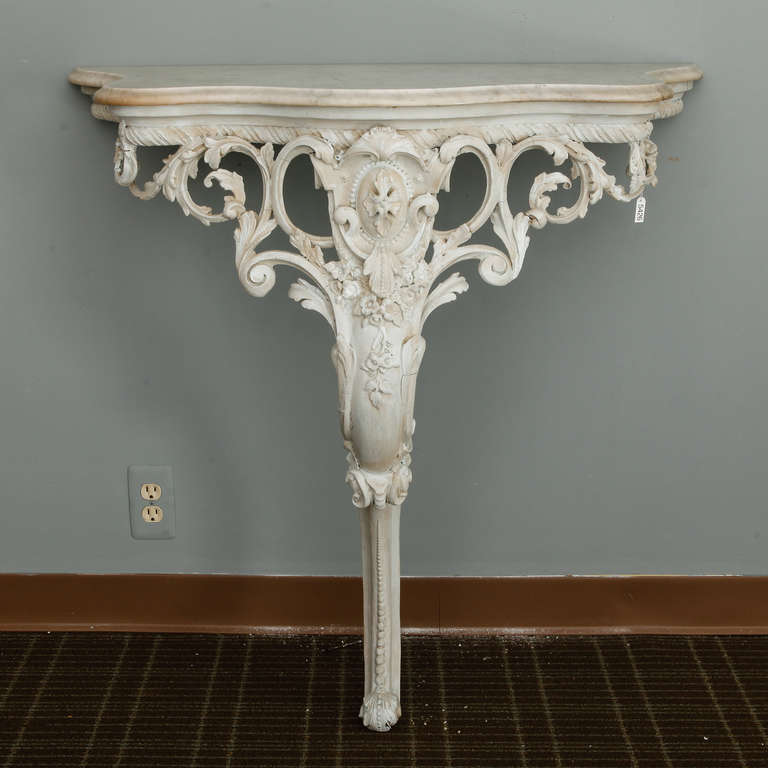 Late 19th century French wall-mounted consoles with elaborately carved, open-work bases, cabriole legs and gray marble table tops. Sold and priced as a pair.
