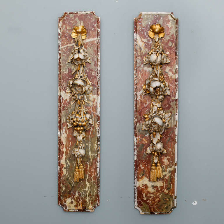 Circa 1880s tall and narrow pair of French wood plaques with beautifully rendered flowers and tassels on a painted and gilded base with a faux marble look. Sold and priced as a pair.
