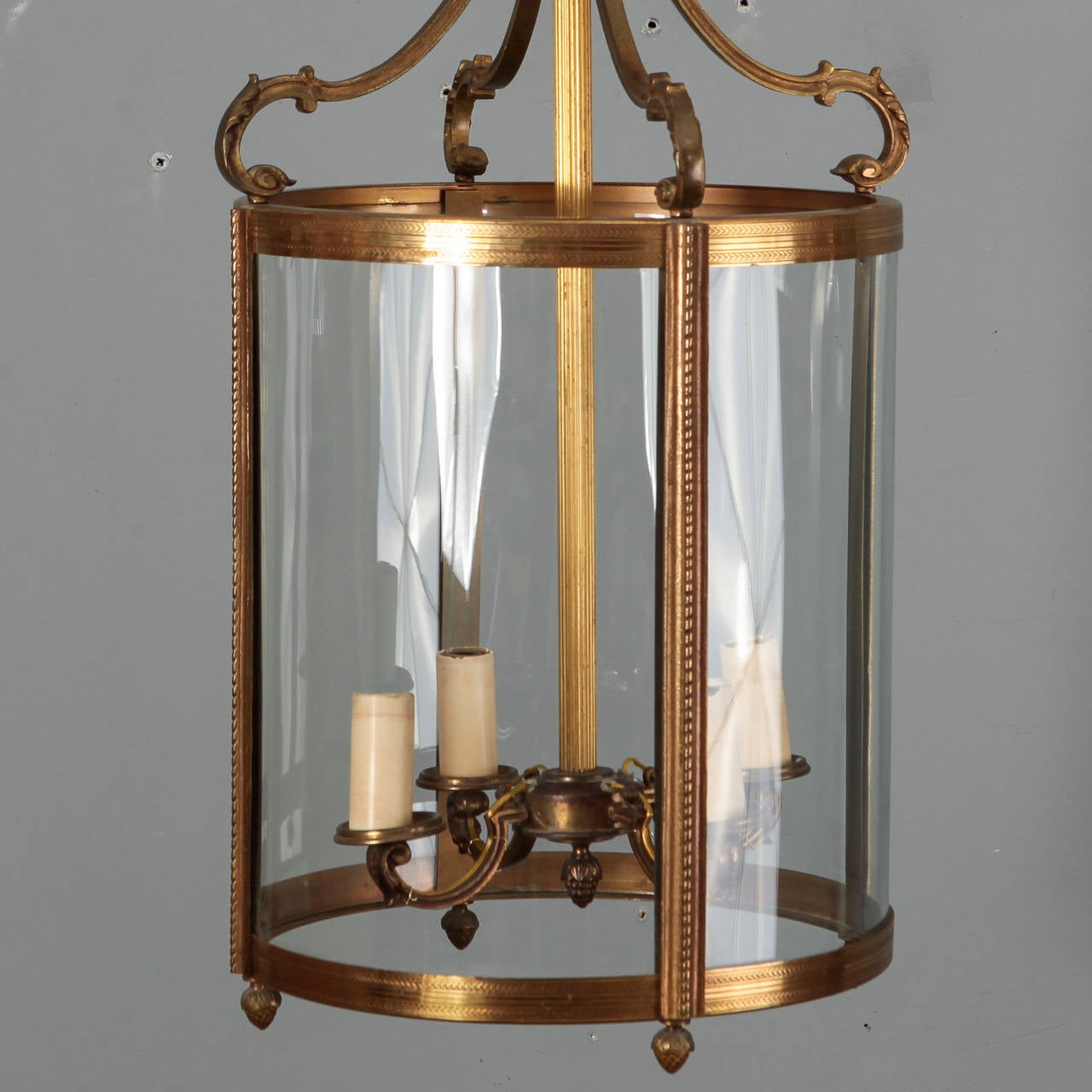 Circa 1920s Dutch bronze lantern fixture with clear glass sides and four internal candle style lights. Design features clean, classic lines with ribbed and braided textural details and a footed base. New electrical wiring for US standards.