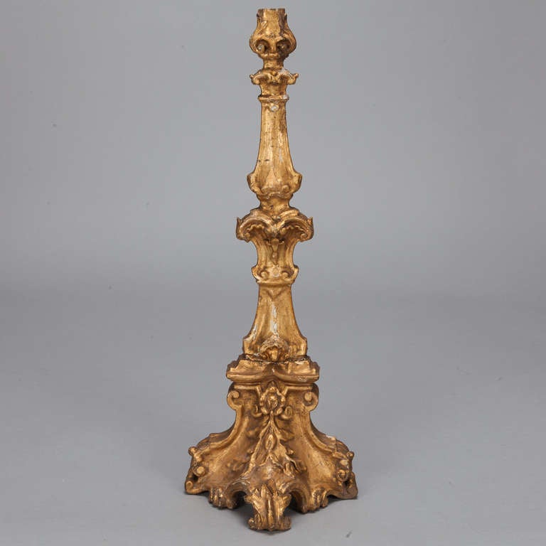 Circa 1900 giltwood candlestick is 2-1/2 feet tall and has an elaborately sculpted base and shaft.