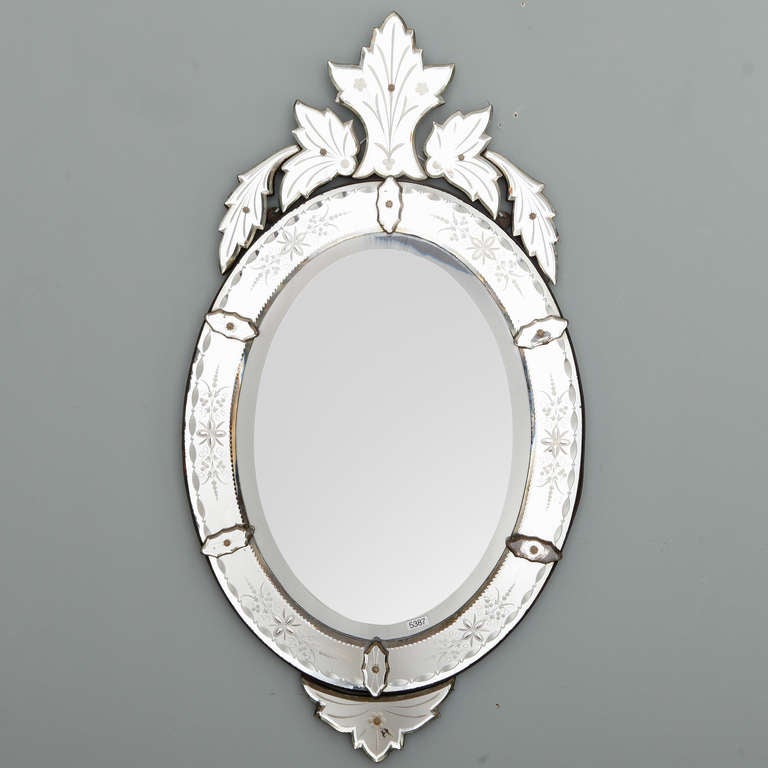 Circa 1920s oval Venetian mirror with etched details and a tall, exuberant crown form crest. Other Venetian mirrors in similar styles, various shapes and sizes available. Please inquire.
