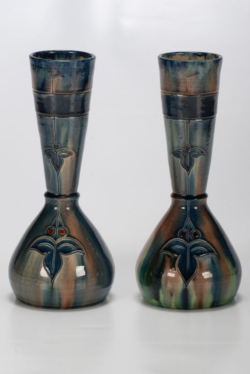 These Arts & Craft vases from Belgium are glazed in blue and green with a leaf and berry design. Priced and sold as a pair.