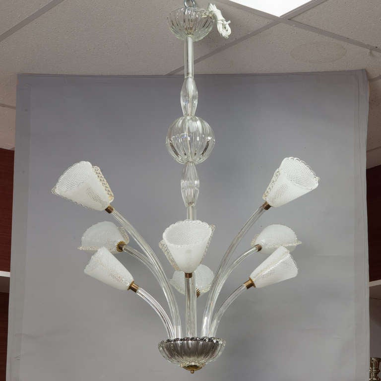 Circa 1930s hand blown Murano glass chandelier attributed to Barovier & Toso. EIght hand blown glass upswept arms of varying height with clear and white striped globes with filigree details at the sides and brass fittings. Central glass shaft with