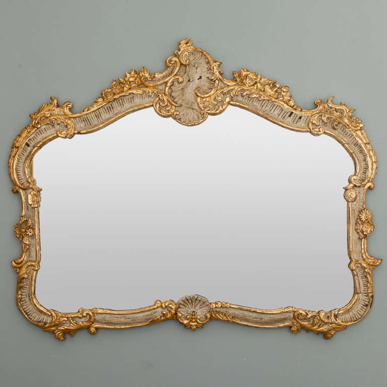Circa 1900 French mirror with elaborate Louis XV style frame in cream and gilded finish.