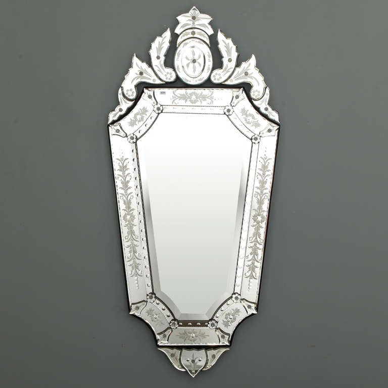 Circa 1980s Venetian glass mirror in classic style with shield shaped mirror and tall, decorative crest.