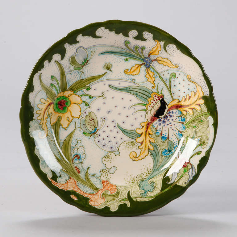 Circa 1970s hand painted Gouda platter or decorative bowl in Jugendstil and Art Nouveau style by now defunct Gouda company GeWi which also produced pottery under the names J.B. Been Pottery, and G.J. and W. Nijhuis.  Each piece is signed and marked
