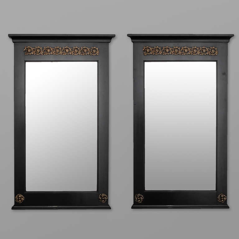 Pair of empire style mirrors with ebonized finish and decorative brass mounts, circa 1920s. Sold and priced as a pair.