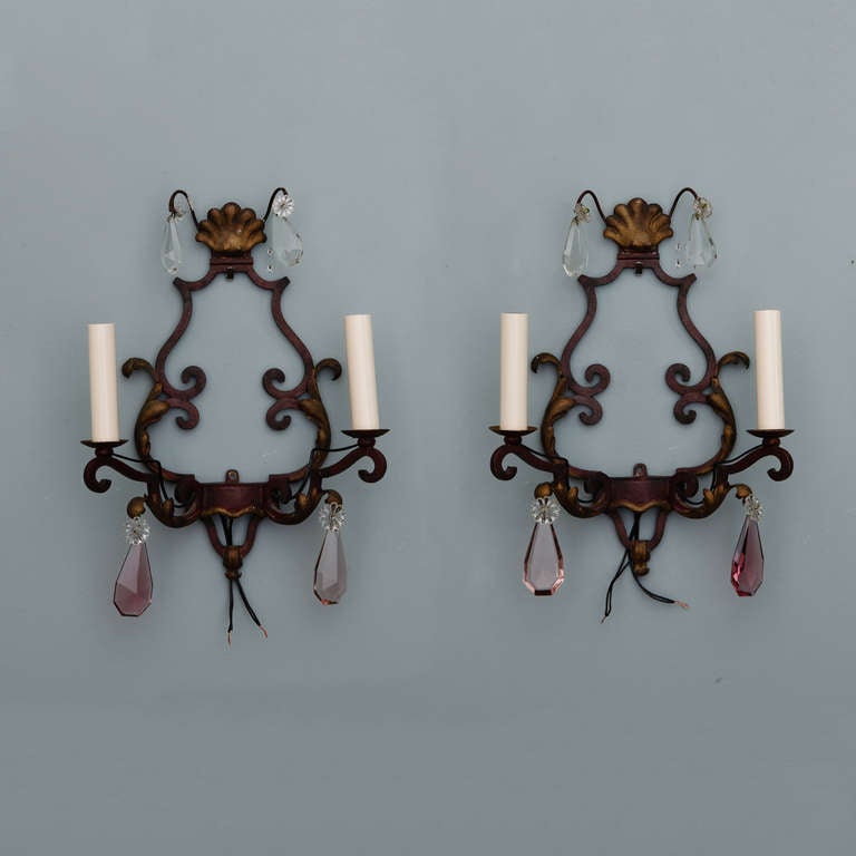 Pair of French sconces, circa 1920s, have scrolled iron back plates with gilded tole leaf and shell form accents, two-candle style lights and large tear drop crystals. New electrical wiring for U.S. standards. Sold and priced as a pair.