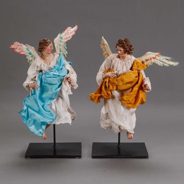 Circa 1940s pair of Italian angels have papier mache wings and bodies with starched cloth garments. Sold and priced as a pair. Mounted on custom made iron stands for display. Stands for both measure 9” X 8”, Measurements shown include