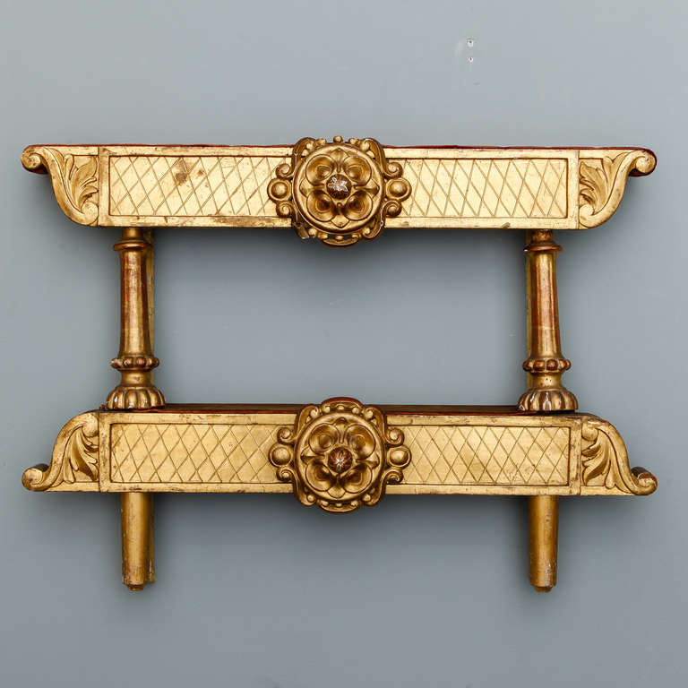 Circa 1880s Italian two tier gilt wood etagere with scrolled detail on ends and carved floral medallions.
