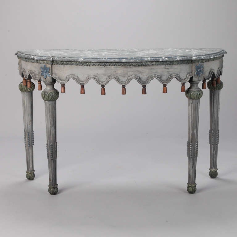 Circa 1825, Swedish demilune table has a blue gray painted finish with reeded and tapered turned legs, decorative apron with gilded wood tassels and a faux marble painted finish on table top.