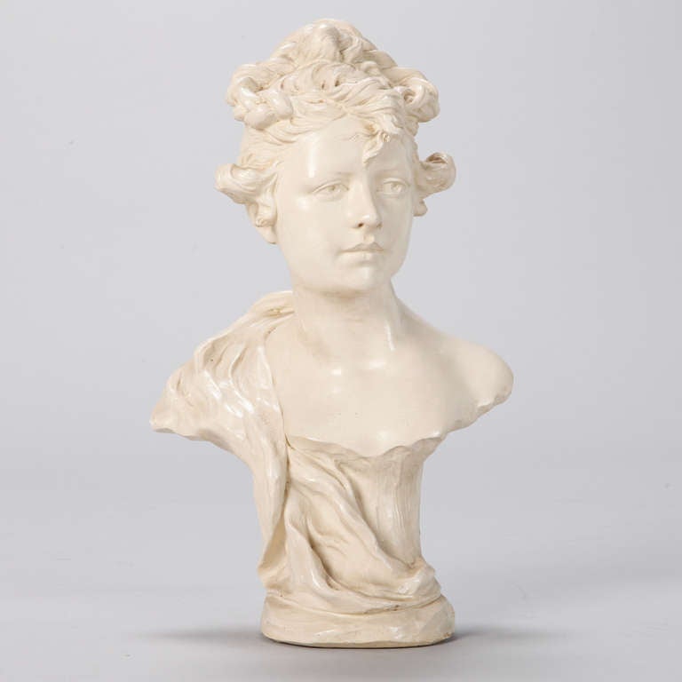 Intricately rendered Art Nouveau era porcelain bust of young woman with 
bare shoulders and upswept hair.