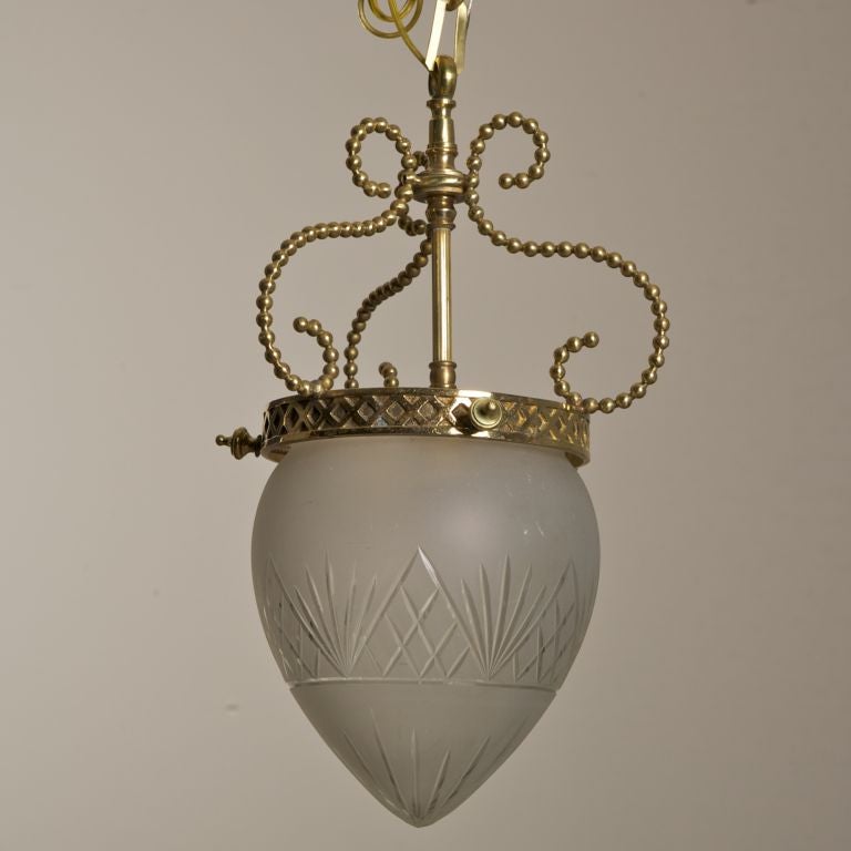 This circa 1920s hanging fixture has an etched tear shaped dome, twisted bronze arms and is suspended by a chain.
# of Sockets: 1
Socket Type: Regular.