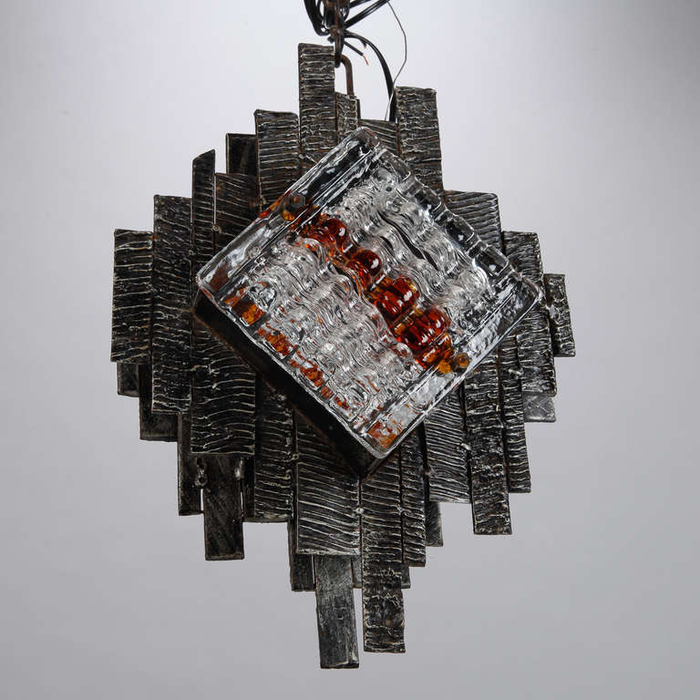 Brutalist style hanging light fixture has welded panels made of flat, dark iron bars of varying lengths with plaques of thick, clear and amber Murano glass attributed to Mazzega, circa 1970s. New electrical wiring for US standards.