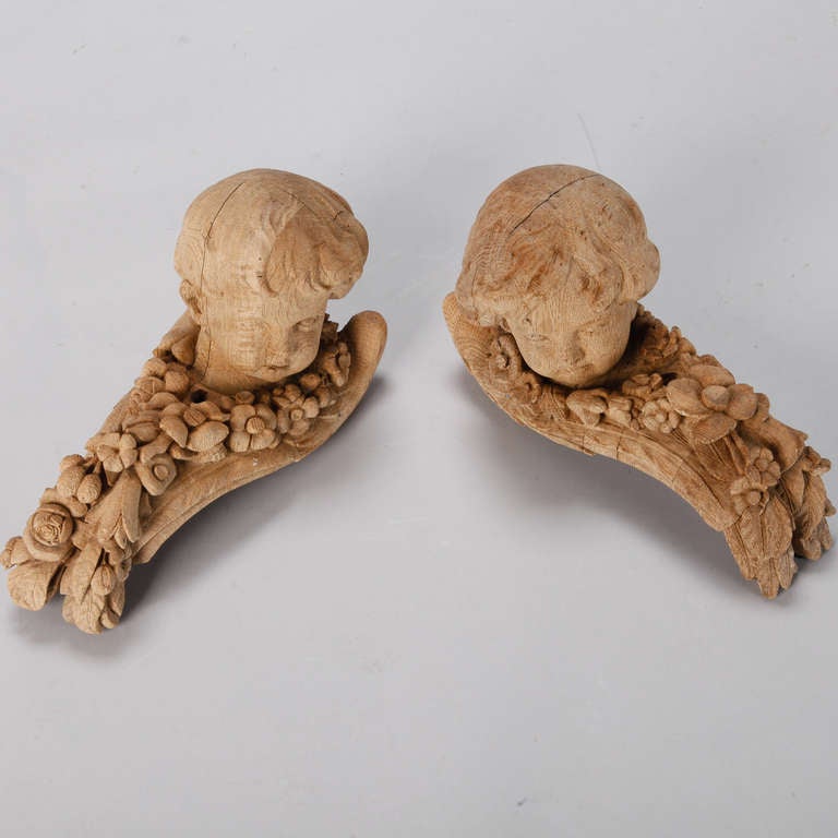 Pair of French bleached oak architectural elements with beautifully carved cherub heads, circa 1880s. Sold and priced as a pair.