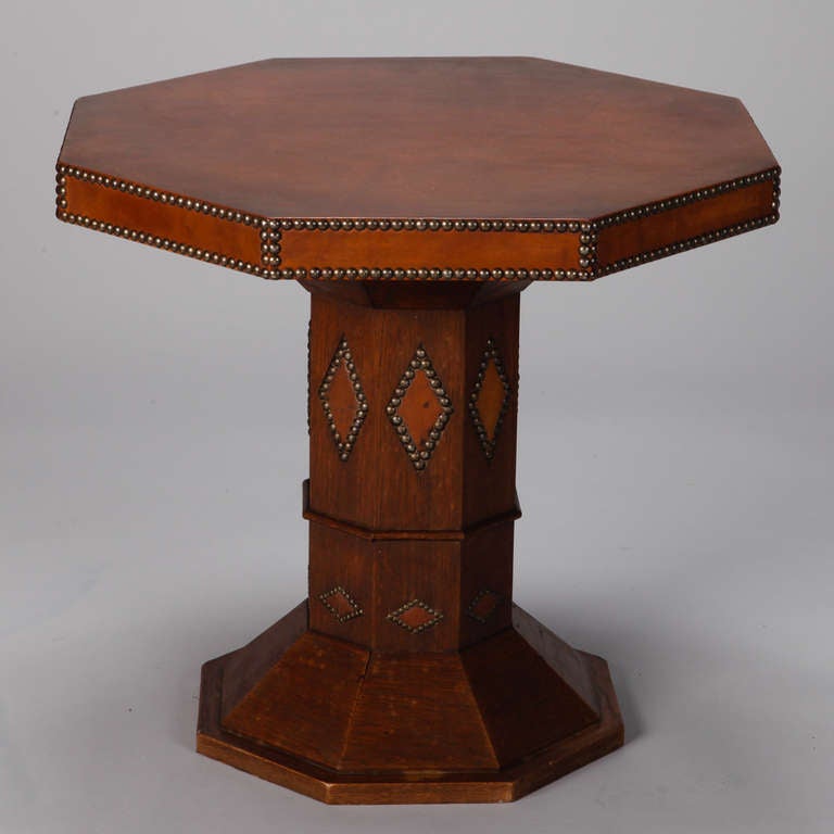 Circa 1930s French Art Deco octagonal center table covered in brown leather with decorative brass nailhead studs.