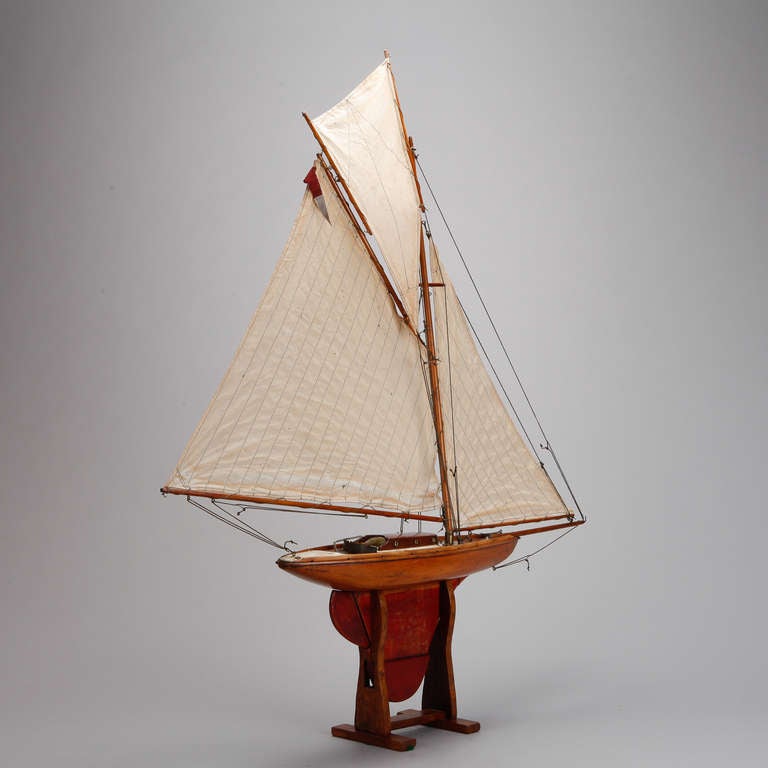 Circa 1900 English pond boat with wood body, brass hardware, original display stand and three cloth sails.