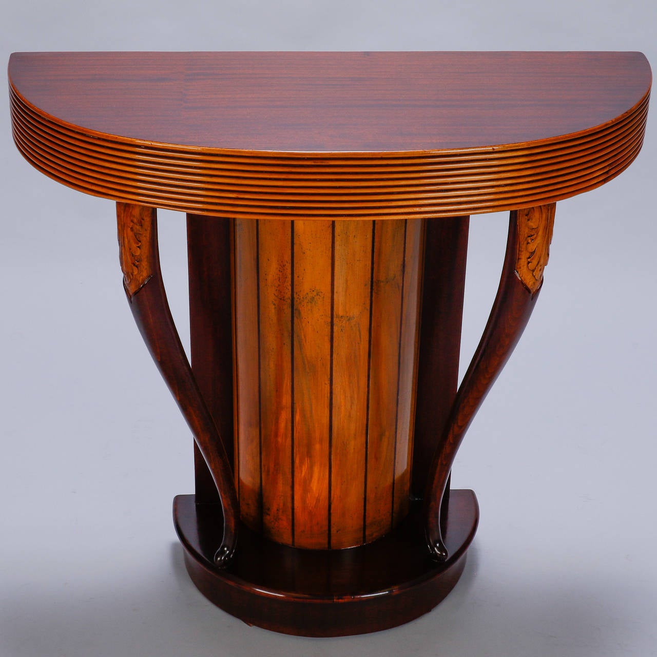 Unusual Art Deco era console found in Italy. Demilune wood top with stacked, reeded apron and pedestal base supported by two cabriole legs with carved foliate detail. 

Dimensions:
31.75” H x 32.5” W x 13.5” D.

Retail: $2,995.00.