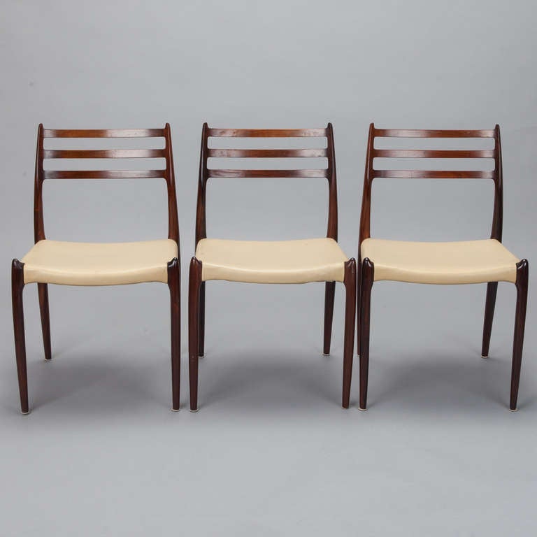 Set of six solid rosewood chairs with original leather seats designed by Niels Moller for J Moller. Original leather shows wear. Pair of #82 armchairs available for separate purchase - please inquire.
