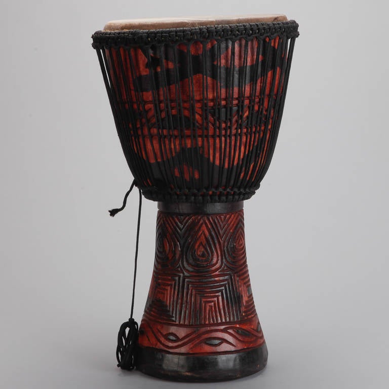 Circa 1980s standing drum from Ghana has a painted and carved base with leather top. Two available. Sold and priced individually.