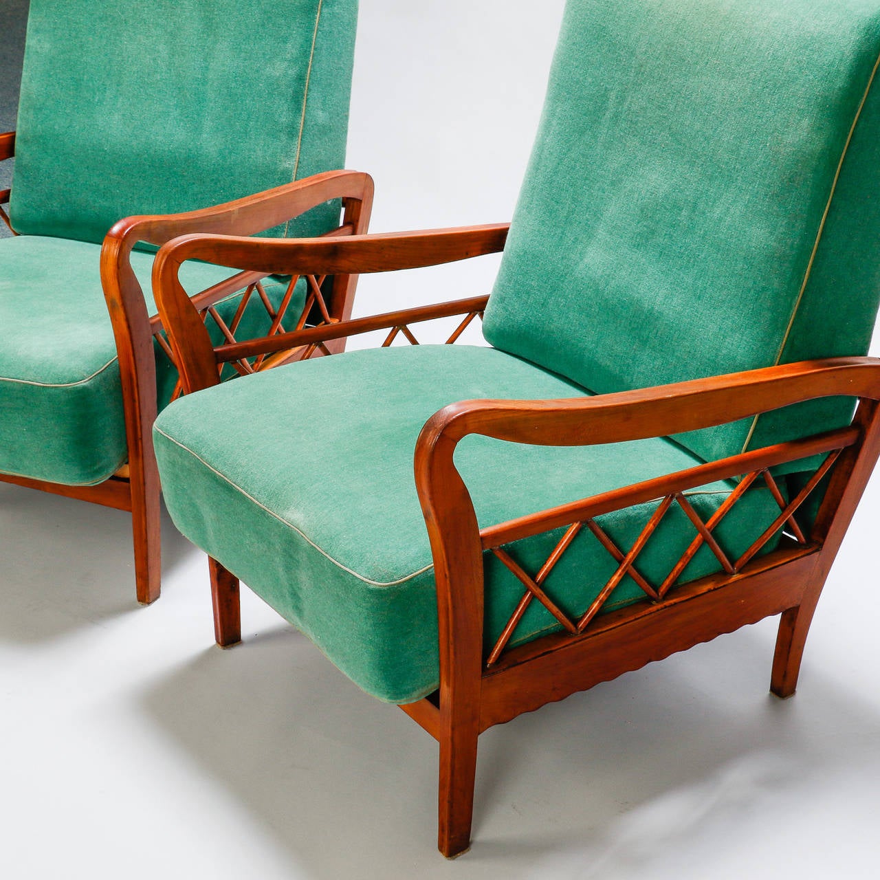 Found in Italy, this pair of circa 1960s lounge chairs feature lattice form details at the sides and curvy armrests. Seats are 15.5