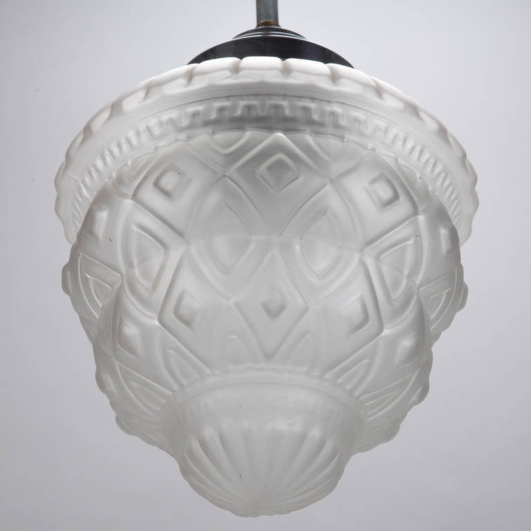 Circa 1930 French Art Deco frosted or satin glass pendant fixture in manner of Charles Schneider. Classic Deco era design elements include geometric surface designs and stepped details on globe. New electrical wiring for US standards.
# of Sockets:
