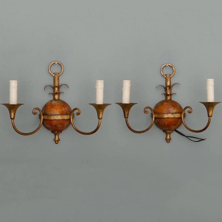Circa 1930s set of four Italian gilded and painted tole ware sconces. Classical design features a round back plate topped with leaves, curved arms, trumpet shaped bobeches and two candle style lights. New electrical wiring for US standards. Sold and