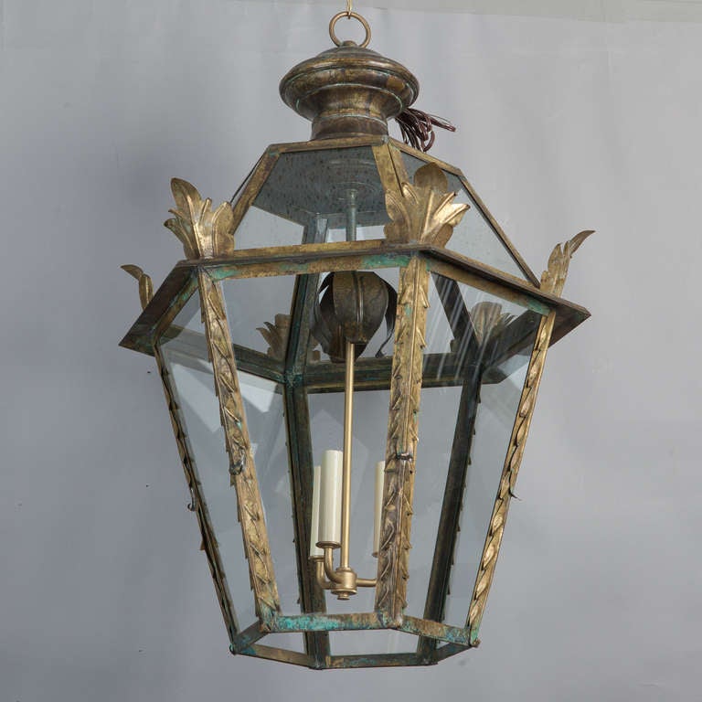These circa 1900 Italian lanterns have a dark brass frame with clear glass panels, three candle style lights each and decorative gilded metal accents. New electrical wiring for US standards. Sold and priced as a pair.