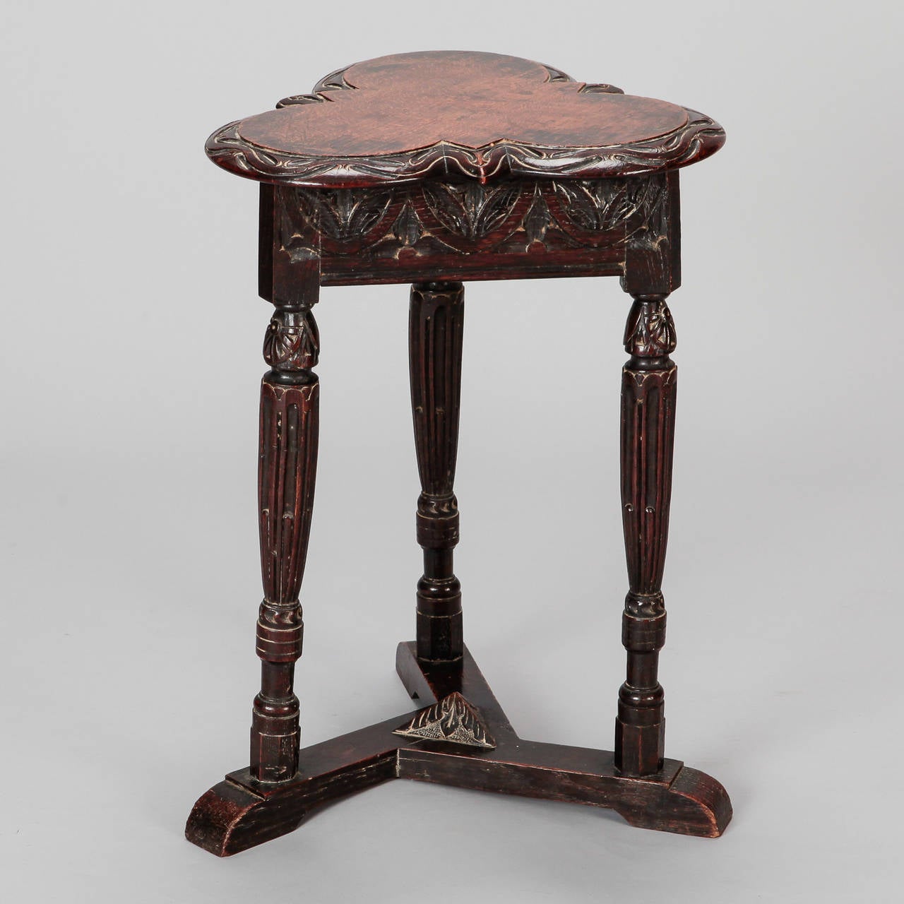 Side table has a trefoil shaped top with highly carved details on apron and turned legs, circa 1890s.