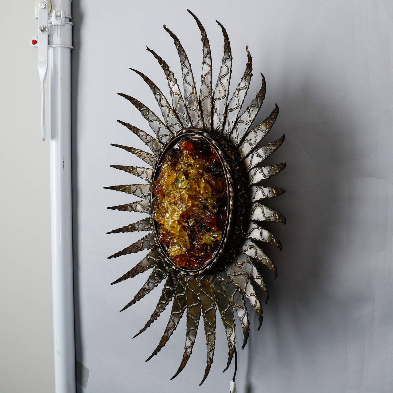 Large, circa 1970s single large sunburst or sunflower form sconce with textured metal petals and chunks of gold colored resin at the center. New wiring for US electrical standards.