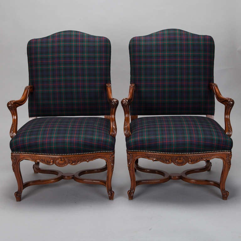 This pair of circa 1880s French armchairs have exposed hardwood frames with hand carved details on the arms, apron, and legs. Newly upholstered in a classic navy blue, green and red wool plaid. Arm Height:  24.5”. Seat Height:  18”. Seat Depth:  22”.