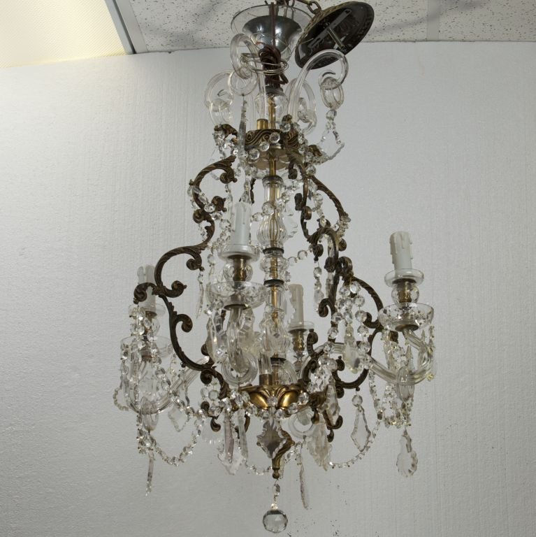 Elaborate late 19th century French chandelier has scrolled metal frame, four glass candle arms, crystal beaded swag, and faceted crystal pendants.
# of sockets: 4
Socket type: Candelabra.