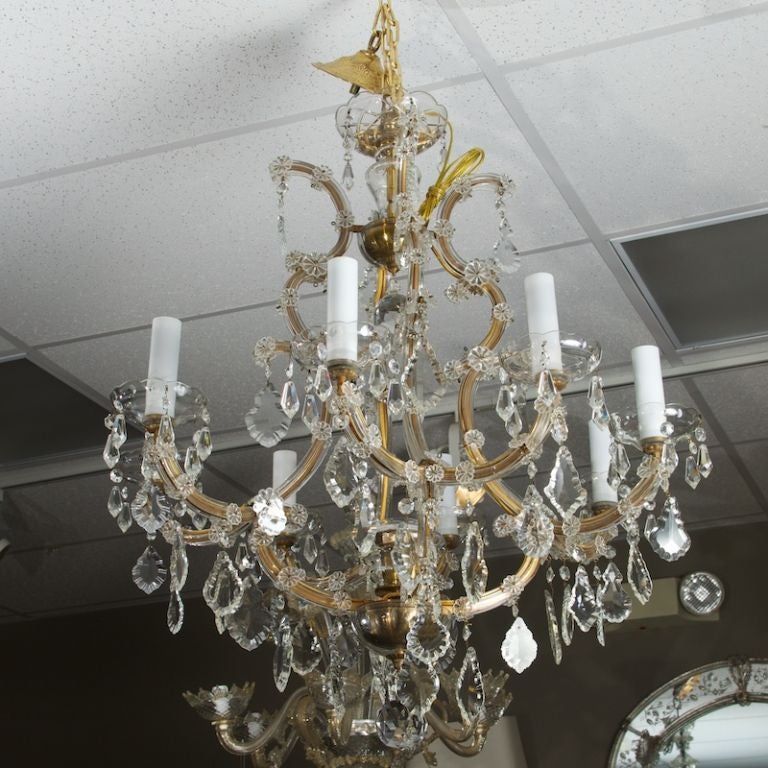 Eight light Maria Theresa style French chandelier with brass arms, and heavy crystal pendants.