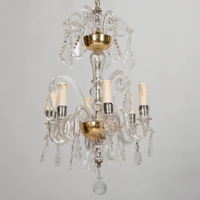 Circa 1920s French chandelier has lower tier of six crystal arms with candle style lights, brass supports and large clear crystal pendants topped with another tier of decorative crystal arms and suspended crystal pendants. New wiring for US
